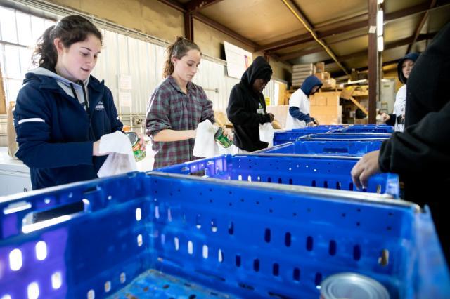 Students help pack canned foods in a food distribution center. 